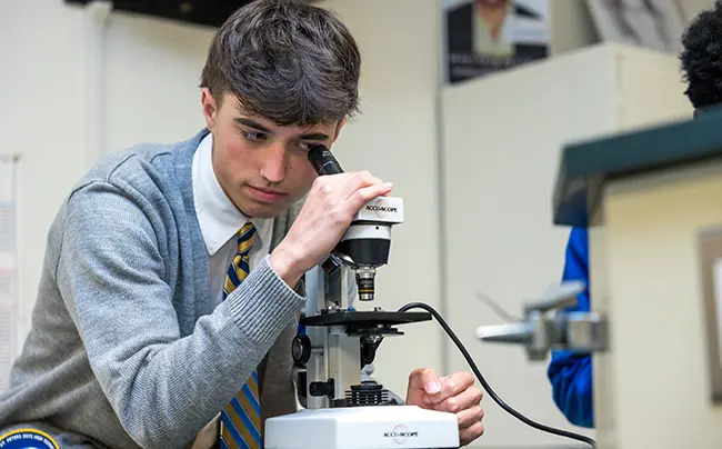 853A4717 a student looking through a microscope