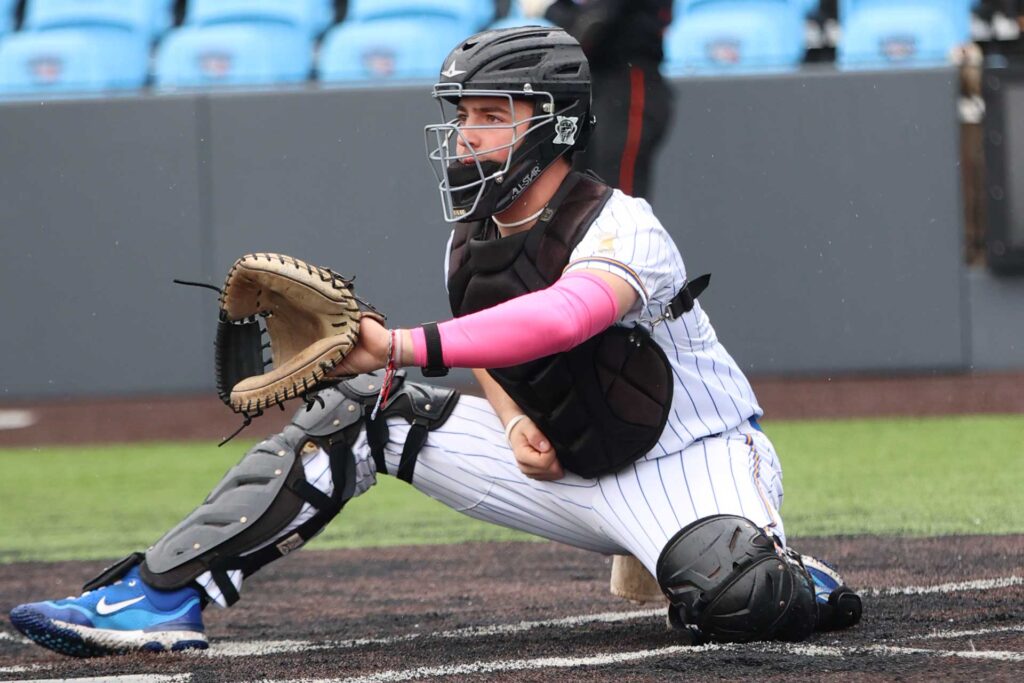 A bseball catcher getting ready to catch a pitch